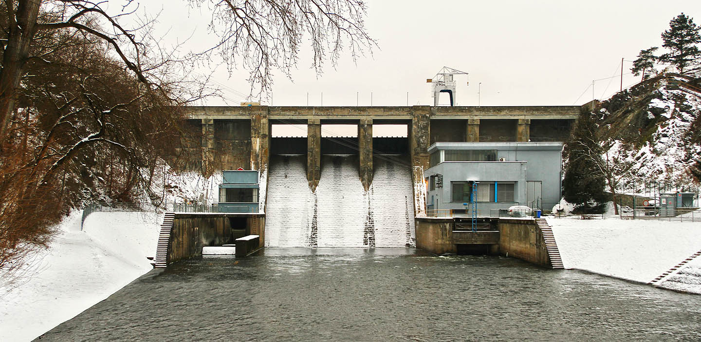 Zimní hráz brněnské přehrady se spodní výpustí na levé straně (pravém břehu), elektrárnou na pravé straně (levém břehu) a jeřábem.