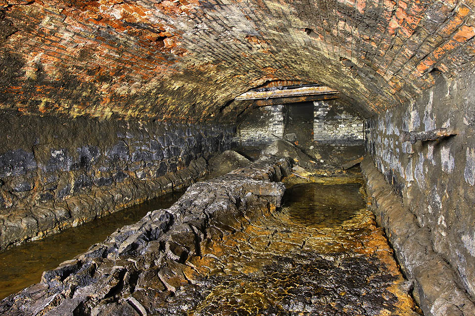 Bývalý propustek pod dolním nádražím je asi nejbarevnějším podzemím v Brně. Namodralé kamenné stěny, cihlově červená klenba a všemi odstíny mezi žlutou a šedou hrající nánosy toxických usazenin vytváří mozaiku téměř všech barev.