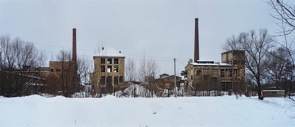 Majestátní komíny nad prázdnou skořápkou továrny se slepými okny lákají pátrače jako maják nad zasněženou krajinou.