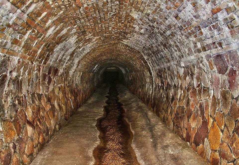 Spodní část tunelu je vystavěná z kamene a cihel.