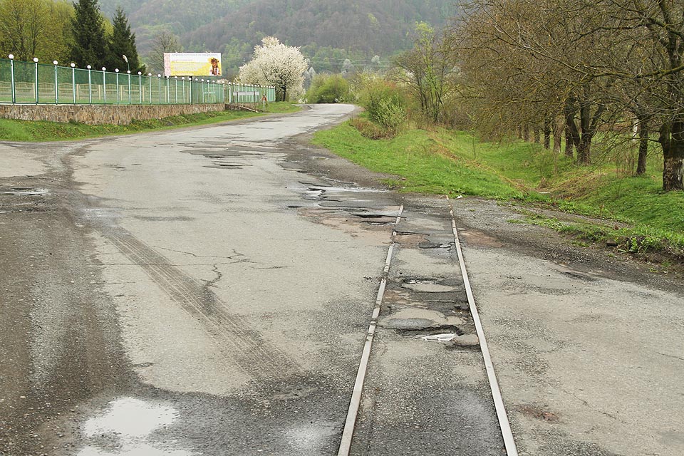 Přejezd pře silnici do Сваляви nad městem Довге. V roce 2017 zde byly koleje sice zarostlé, nciméně stále na svém místě. Vlevo plot sanatoria Боржава, které využívá vodu z nedalekých minerálních pramenů.