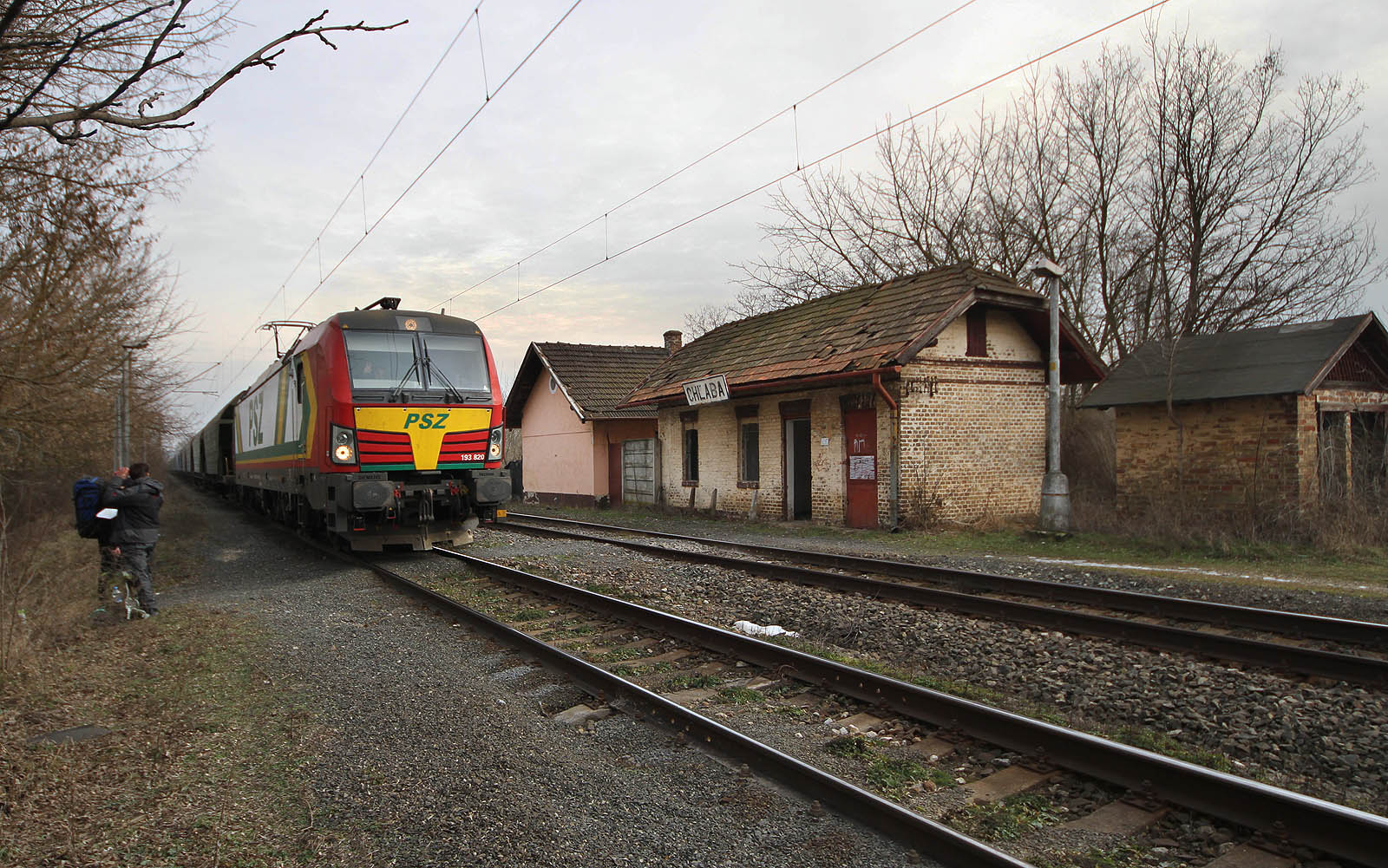 Vektron 193 820 Prvé Slovenské železničné akciové spoločnosti s nákladem zrní uhání z úrodné panonské nížiny na severozápad skrze zastávku Chľaba.