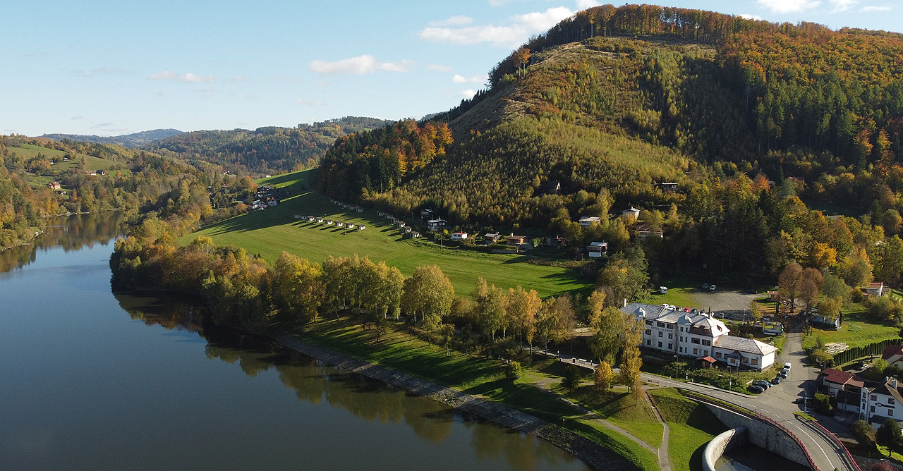 Pohled na hladinu vodní nádrže Bystřička znad její hráze s hotelem i vrcholem Klenovem v pravé části snímku. Pohled na hladinu vodní nádrže Bystřička znad její hráze s hotelem i vrcholem Klenovem v pravé části snímku.