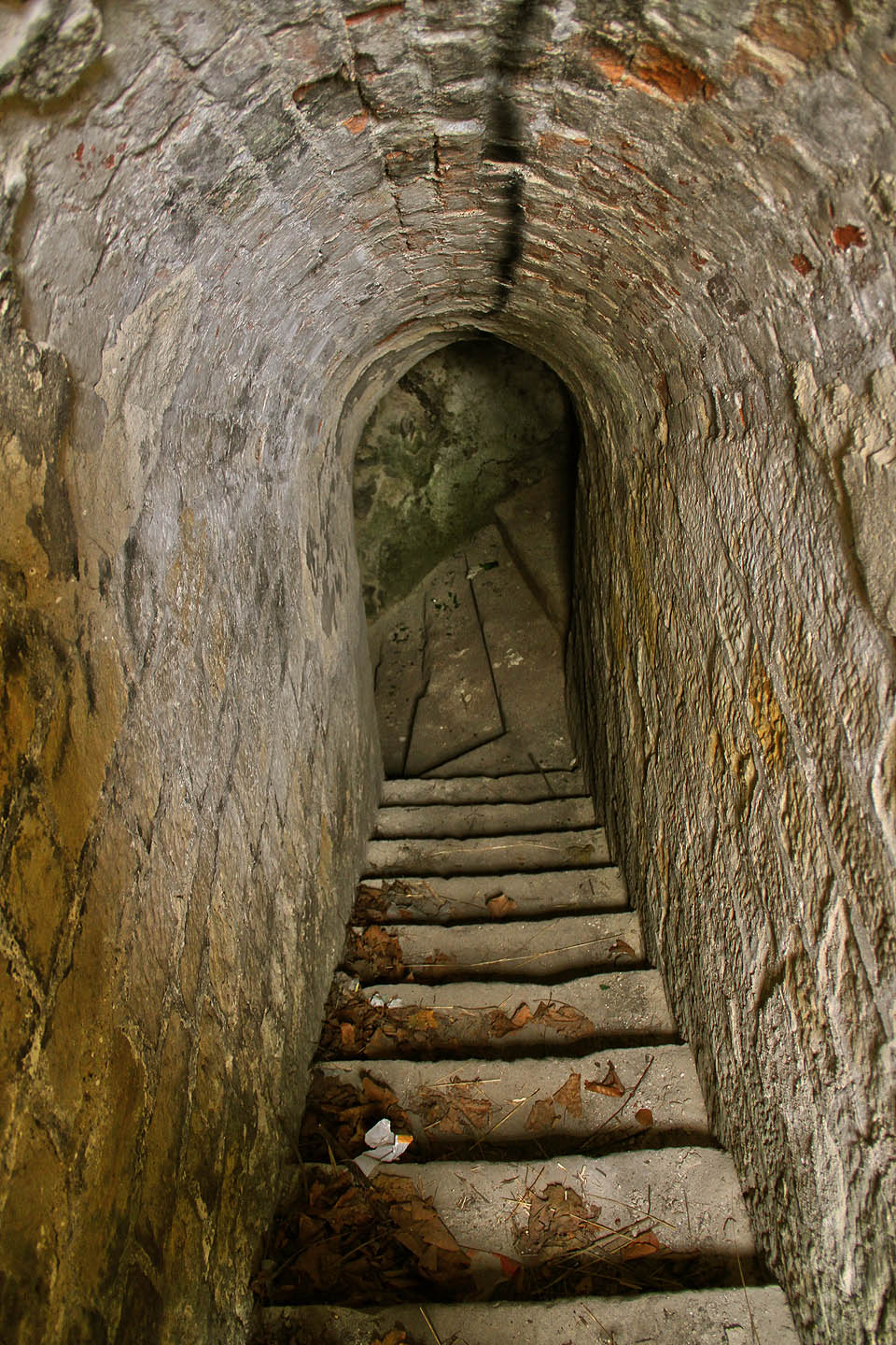 Úzkým schodištěm z 18. století sestupujeme do stísněných prostorů mezi masivními zdmi a tisíci tun navršené zeminy a skal.