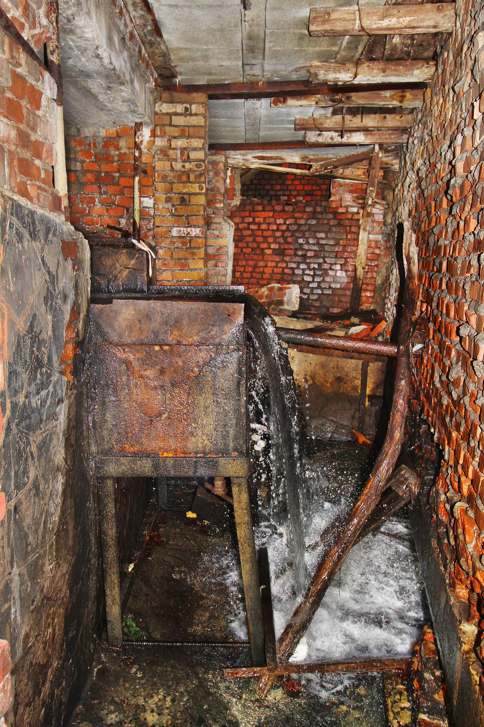 Tahle voda z podzemí měla původně napájet komplex, který by dnes nejspíš nesl název aquapark. Místo toho mizí ve škvíře pod základovým nosníkem další z budov.