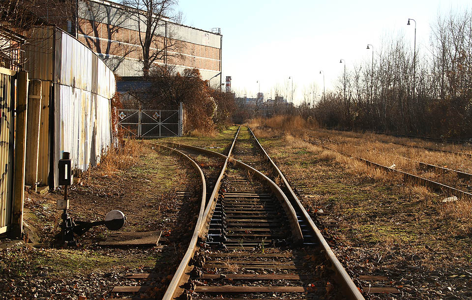 Vlečkovou výhybkou č. 4 odbočuje jedna z kolejí, které prochází branami a noří se hlouběji do spletitého továrního areálu.