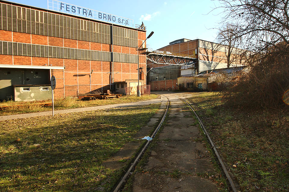 Za branou se nachází spletitá síť kolejí, cest, jeřábů a budov - jeden z největších průmyslových areálů v Brně.