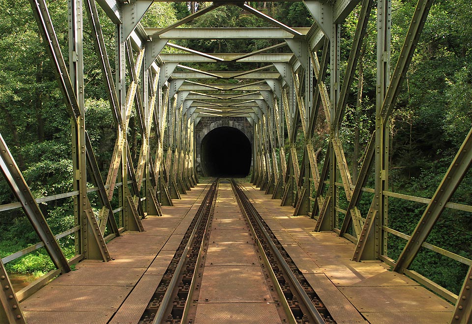Vjezd do Malého Plasského tunelu od severu je přímo z příhradového mostu přes řeku Střelu.
