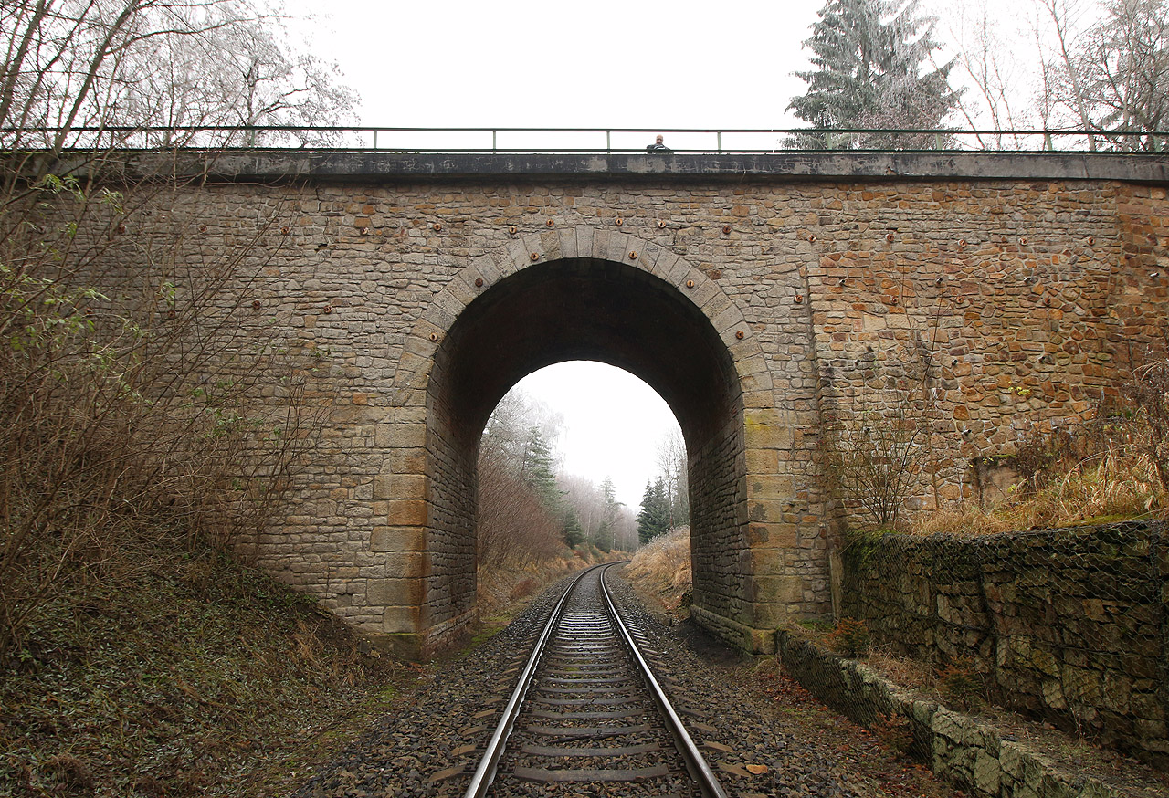 Kamenný most přes chomutovskou trať. Úzkokolejné vlaky jezdily nad kolejemi normálního rozchodu po stavbě zvané údajně Červený kanál.