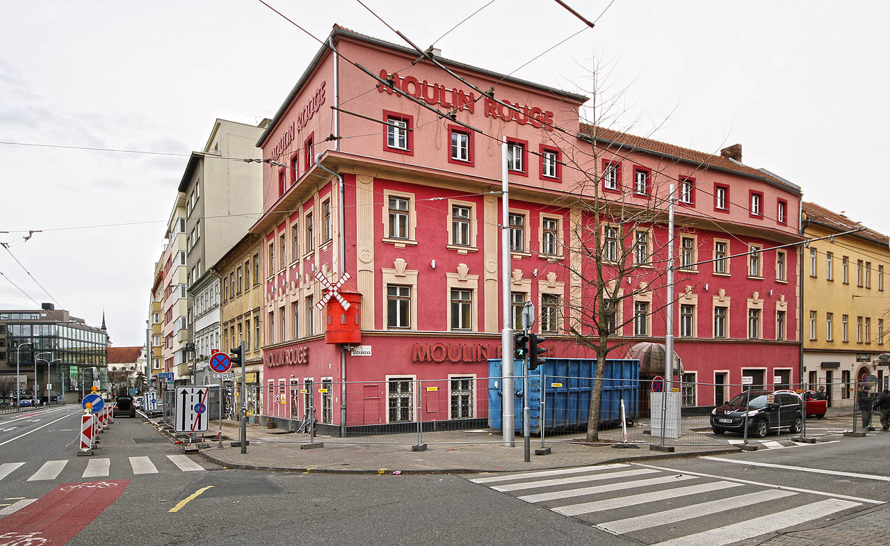 Nároží Kounicovy (vlevo) a Slovákovy (vpravo) ulice na počátku roku 2022. Podniku Moulin Rouge tou dobou již odtikávají poslední hodiny existence. Dobře je patrný rozdíl mezi původním honosnějším domem vlevo a pavlačákem obráceným do Slovákovy ulice, jež byly druhotně sjednoceny.