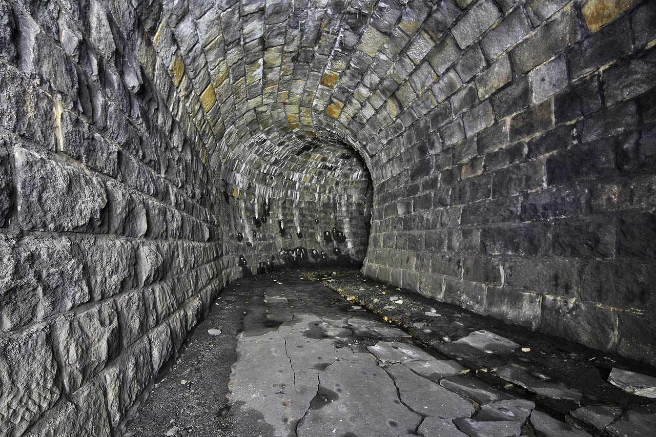 Podlaha v nikdy nedokončené továrně je rozpraskána zřejmě vlivem pohybů podkladové horniny. Může to být ale také mrazem díky proudícímu chladnému vzduchu z tunelu do šachty.