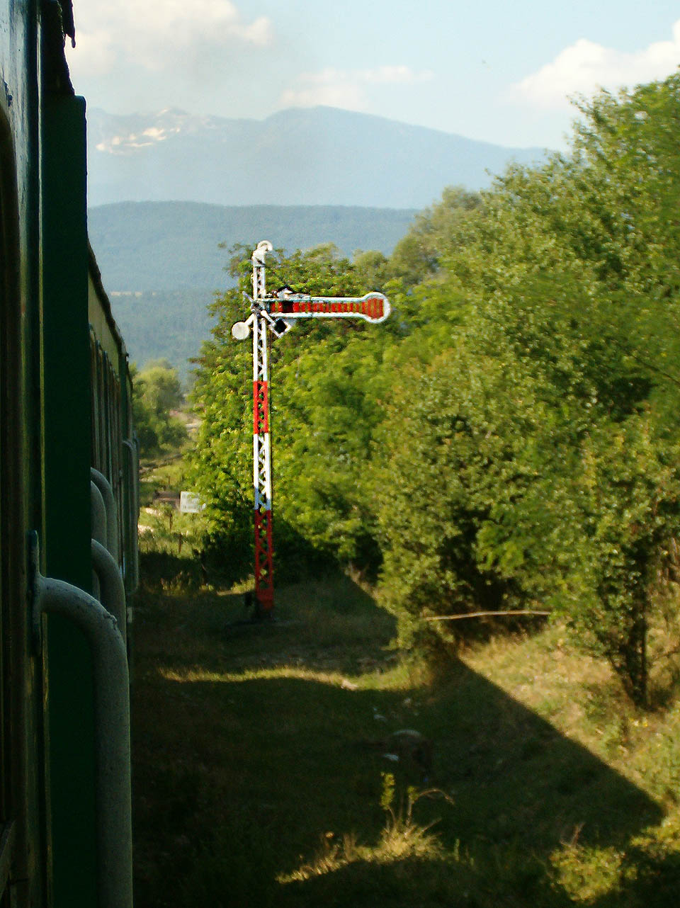 Vjezdové návěstidlo do konečné stanice Добринище na pozadí nejvyššího balkánského pohoří - Мусали в Риле.