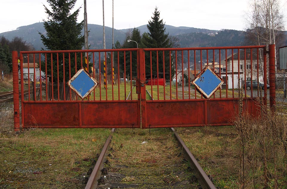 Červená vrata na odvratné koleji naproti modrým vratům na hlavní větvi vlečky.
