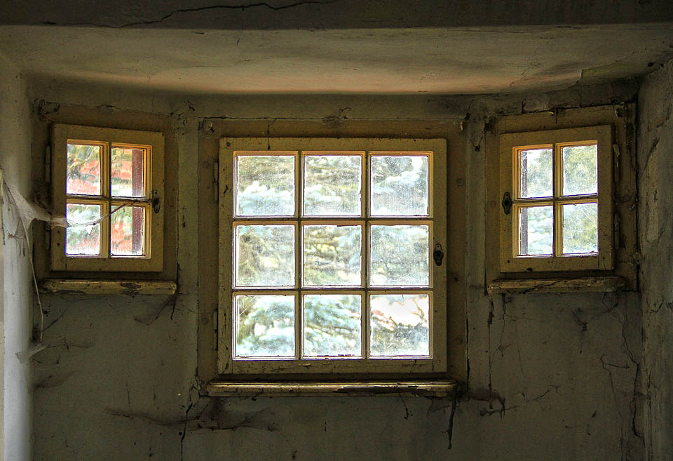 Okna dřevěné střešní věžičky jako by připomínala střílny právě skončené světové války.