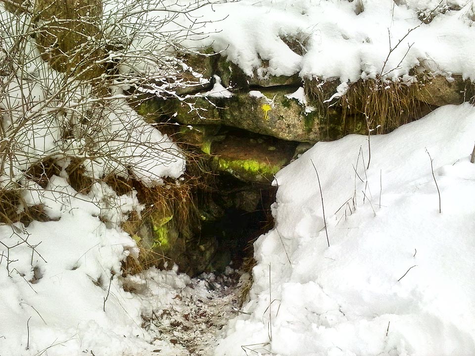 Nenápadný vstup do štoly v zídce ukryté na mezi označuje žlutý list ginga, stejně jako další zajímavá místa v okolí Nejdku. V zimě jej navíc zdobí ledové stalagmity.